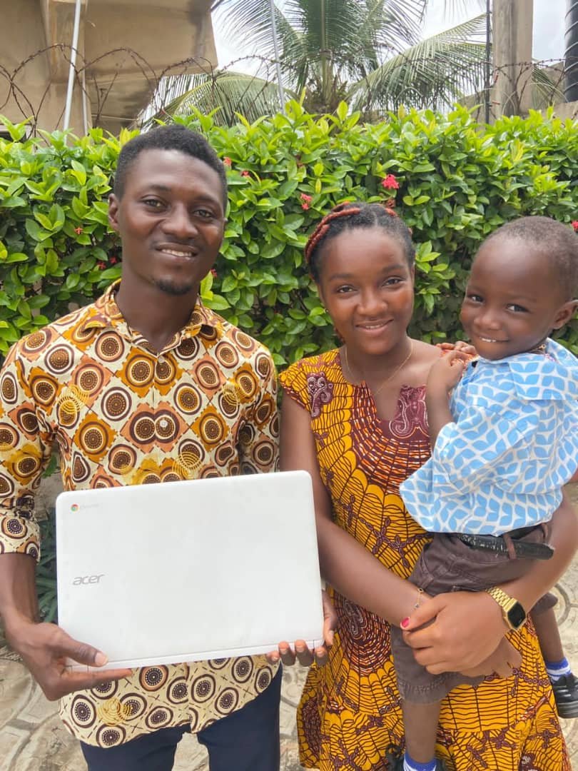 A laptop recipient with their family in Ghana